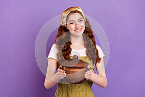 Photo of charming pretty lovely young woman cook food hold hands wooden pot isolated on purple color background