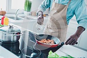 Photo of charming professional age man wear apron smiling frying veggy dish pouring oil indoors room home