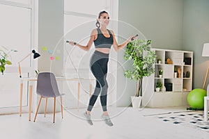 Photo of charming sexy young lady wear sport outfit smiling cardio training jumping rope indoors home house