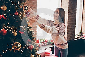 Photo of charming shiny mature woman wear print sweater smiling decorating christmas tree indoors house home room