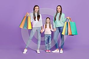 Photo of charming sweet daughters mom dressed casual sweaters having shopping smiling isolated purple color background