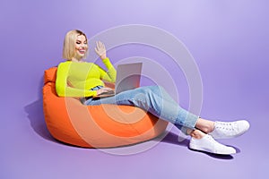 Photo of cheerful adorable girl wear trendy clothes chatting telegram whatsup followers empty space isolated on purple photo