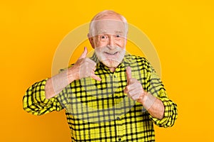 Photo of cheerful aged man happy positive smile show fingers call sign you phone isolated over yellow color background