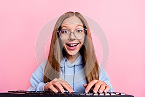 Photo of cheerful astonished girl toothy smile keyboard write typing isolated on pink color background