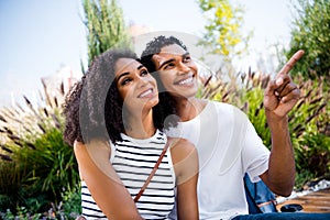 Photo of cheerful charming couple traveling in city on weekend trip watching sightseeings admiring architecture outdoors