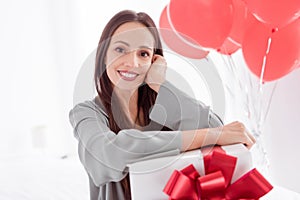 Photo of cheerful charming lady wear grey pajama enjoy getting birthday surprise indoors house bedroom