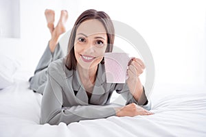 Photo of cheerful charming lady wear grey pajama enjoy weekend drinking coffee indoors house bedroom