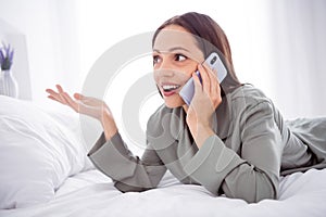 Photo of cheerful charming lady wear grey pajama enjoy weekend talking modern device indoors house bedroom