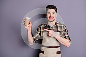 Photo of cheerful confident attractive handsome man pointing at disposable cup of coffee recommending you this sort