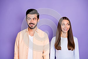 Photo of cheerful couple wear blue sweater orange shirt look copyspace amazed isolated on purple color background