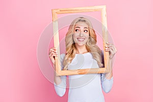 Photo of cheerful dreamy young woman look empty space good mood frame isolated on pink color background