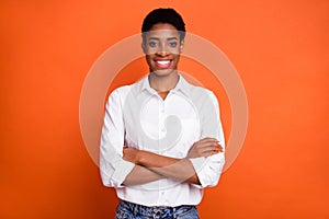 Photo of cheerful emotion successful business person with folded hands isolated on orange color background