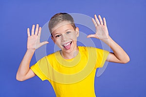 Photo of cheerful foolish preteen boy teasing fooling grimacing  on purple color background photo