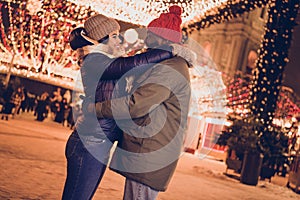 Photo of cheerful funny husband wife wear winter season clothes hugging celebrating xmas outside urban city street