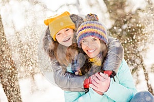 Photo of cheerful girls mommy daughter happy positive smile hug cuddle embrace snowy weather enjoy time together