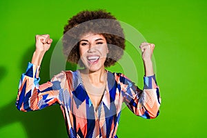 Photo of cheerful glad cute woman wear trendy clothes raise hands good mood isolated on vibrant green color background