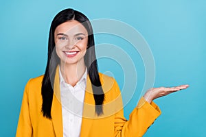 Photo of cheerful happy nice young business woman hold hand empty space objcet show isolated on blue color background