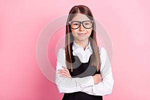 Photo of cheerful happy positive small girl hold hands crossed confident glasses  on pink color background
