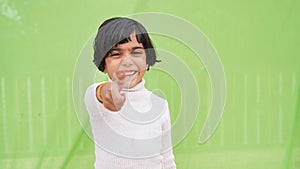 Photo of cheerful happy young small girl make fingers thumbs up smile recommend isolated on green color background
