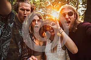 Photo of cheerful hippies men and women, smiling and taking self