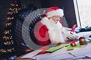 Photo of cheerful impressed santa claus dressed red costume online sale shopping modern device indoors christmas north