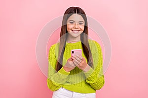 Photo of cheerful lovely girl toothy smile hold use telephone chatting isolated on pink color background
