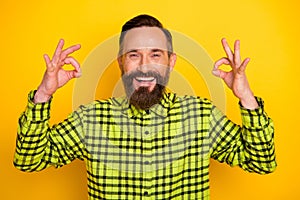 Photo of cheerful man happy positive smile show okey sign deal done ad promo choice recommend isolated over yellow color