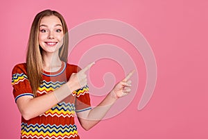 Photo of cheerful nice girl toothy smile indicate fingers empty space ad isolated on pink color background