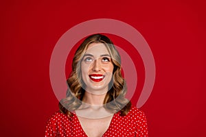 Photo of cheerful nice lovely girl toothy smile look interested up empty space ad isolated on red color background