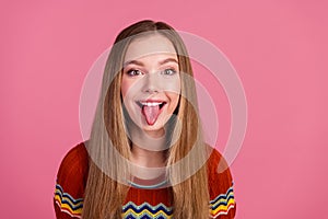Photo of cheerful overjoyed girl toothy smile showing tongue out empty space isolated on pink color background