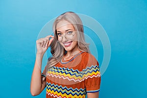 Photo of cheerful positive girl dressed print shirt arm eyewear empty space isolated blue color background