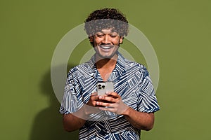 Photo of cheerful positive guy wear print shirt communicating instagram twitter telegram facebook isolated khaki color