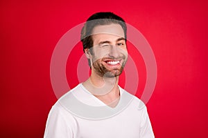 Photo of cheerful positive happy charming man wink eye good mood smile isolated on red color background