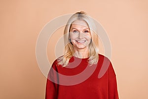 Photo of cheerful positive lady dressed red pullover smiling empty space isolated beige color background
