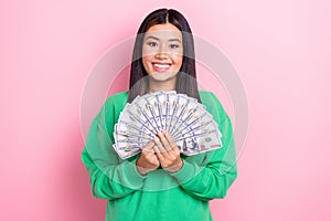 Photo of cheerful positive lady wear green sweatshirt holding money fan isolated pink color background