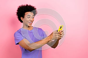 Photo of cheerful positive man blogger wear purple stylish clothes writing typing sms modern gadget isolated on pink