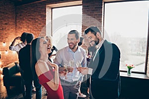 Photo of cheerful positive nice pretty girl laughing with other men joking at her holding glasses of alcohol wearing