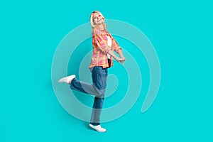 Photo of cheerful positive senior woman wear checkered stylish clothes have fun isolated on cyan color background