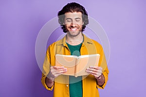 Photo of cheerful positive smile young man read book information isolated over violet color background