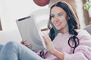 Photo of cheerful positive young woman hold look tablet read smile indoors inside house living room