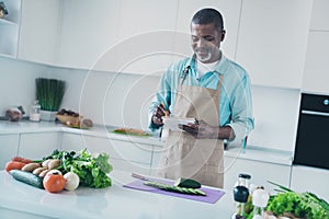 Photo of cheerful pretty age man wear apron inventing new cooking recipe indoors room home