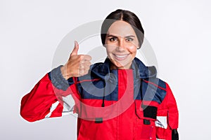 Photo of cheerful shiny young urgency woman wear red jacket smiling showing thumb up isolated white color background