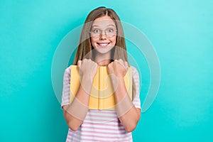 Photo of cheerful smart girl toothy smile arms hold hug book isolated on turquoise color background