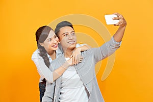Photo of cheerful trendy charming cute nice couple of two people taking selfie smiling toothily hugging isolated yellow color