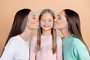 Photo of cheerful trendy generation woman kiss girl cheek affection isolated on pastel beige color background