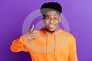 Photo of cheerful young dark skin man make thumb up amazed recommend isolated on purple color background