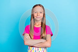 Photo of cheerful young happy confident small girl hold hands crossed isolated on pastel blue color background