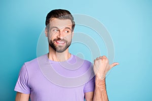 Photo of cheerful young man happy smile indicate thumb empty space advice choose promo isolated over blue color