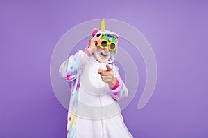 Photo of childish funny man pensioner unicorn sleepwear dark pineapple glasses pointing you isolated violet color photo