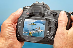 Photo of church and sea on camera display during the summer vacation. Travel photography